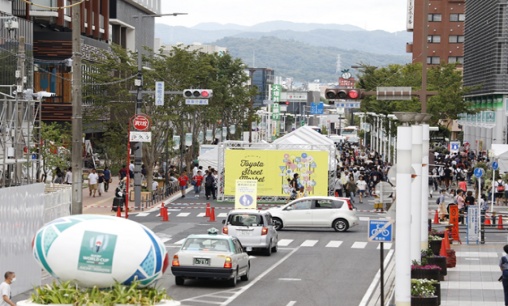 （駅前の大きな通りを完全に封鎖し、実施。出店は道路中央に位置し、緊急車両の通行幅の確保と（歩道の）歩行者にも見える配置。）