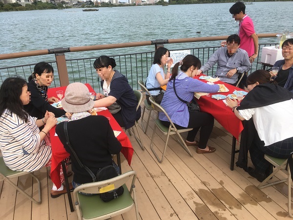 バスツアープログラムの一つである千波公園における食事会の様子