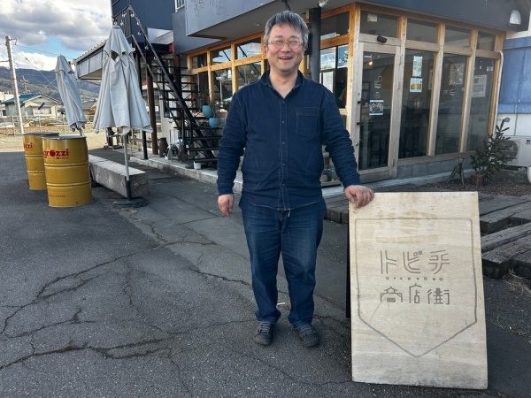 トビチ商店街のロゴ看板と赤羽さん